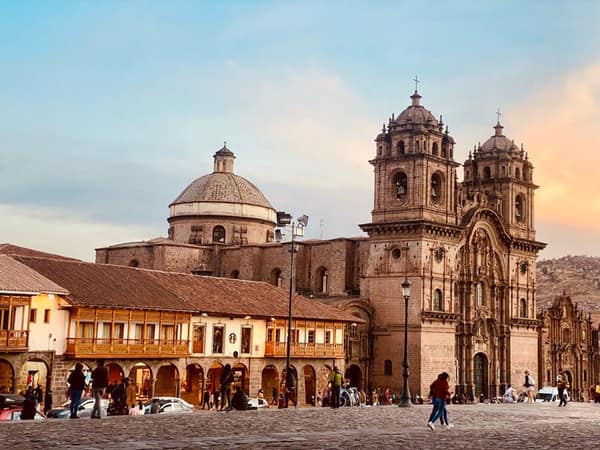 Cusco's Plaza de Armas at sunset, Inca stonework and colonial towers glowing gold